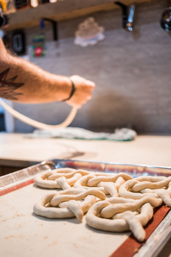 A man shaping pretzels into their classic twisted shape