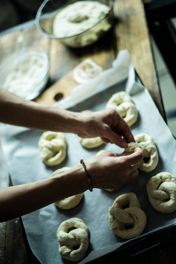Worker rolling dough into homemade twisted pretzels