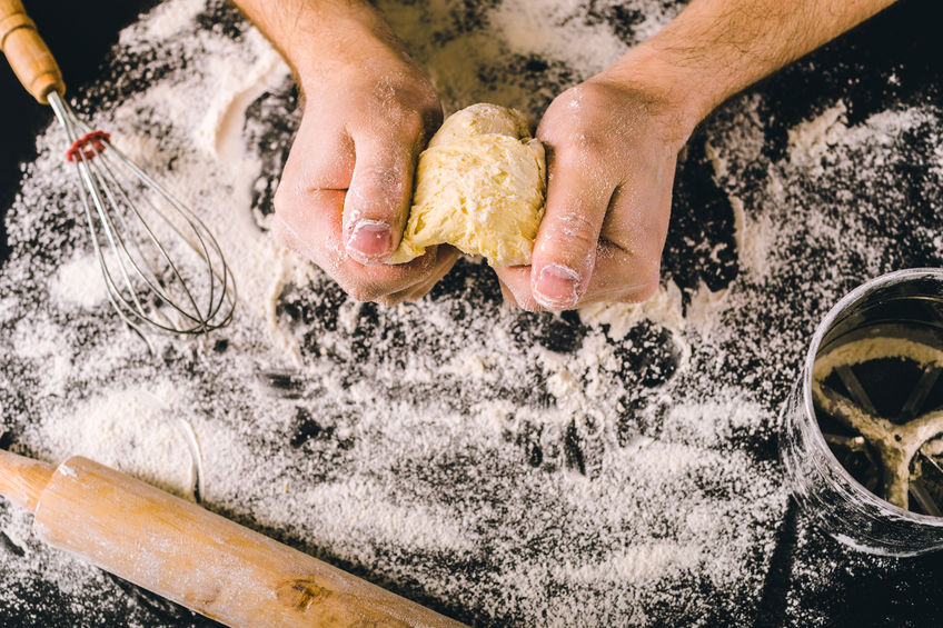 Hands kneading a dough to make pretzels